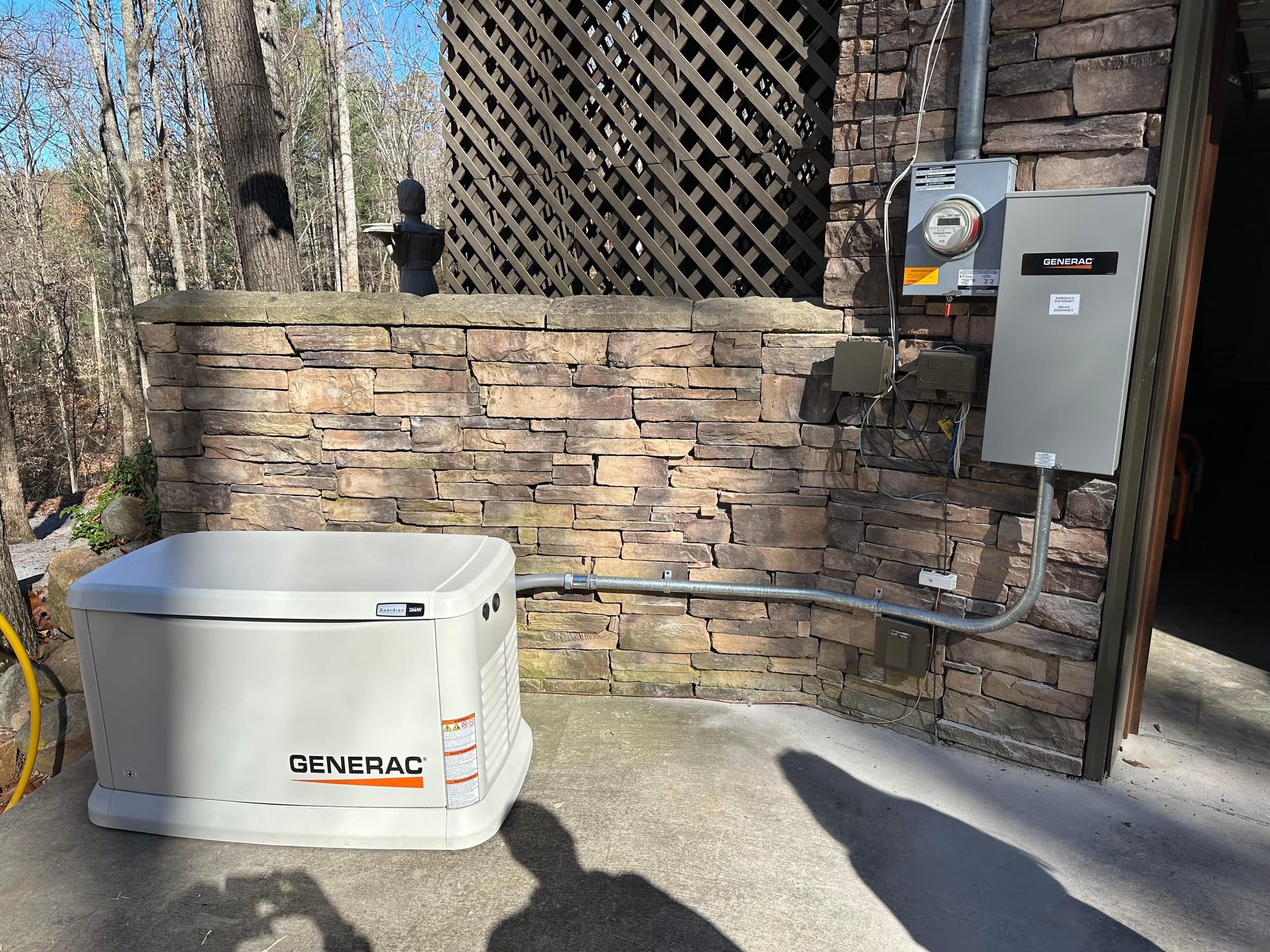 Generac standby generator installed beside a stone exterior wall