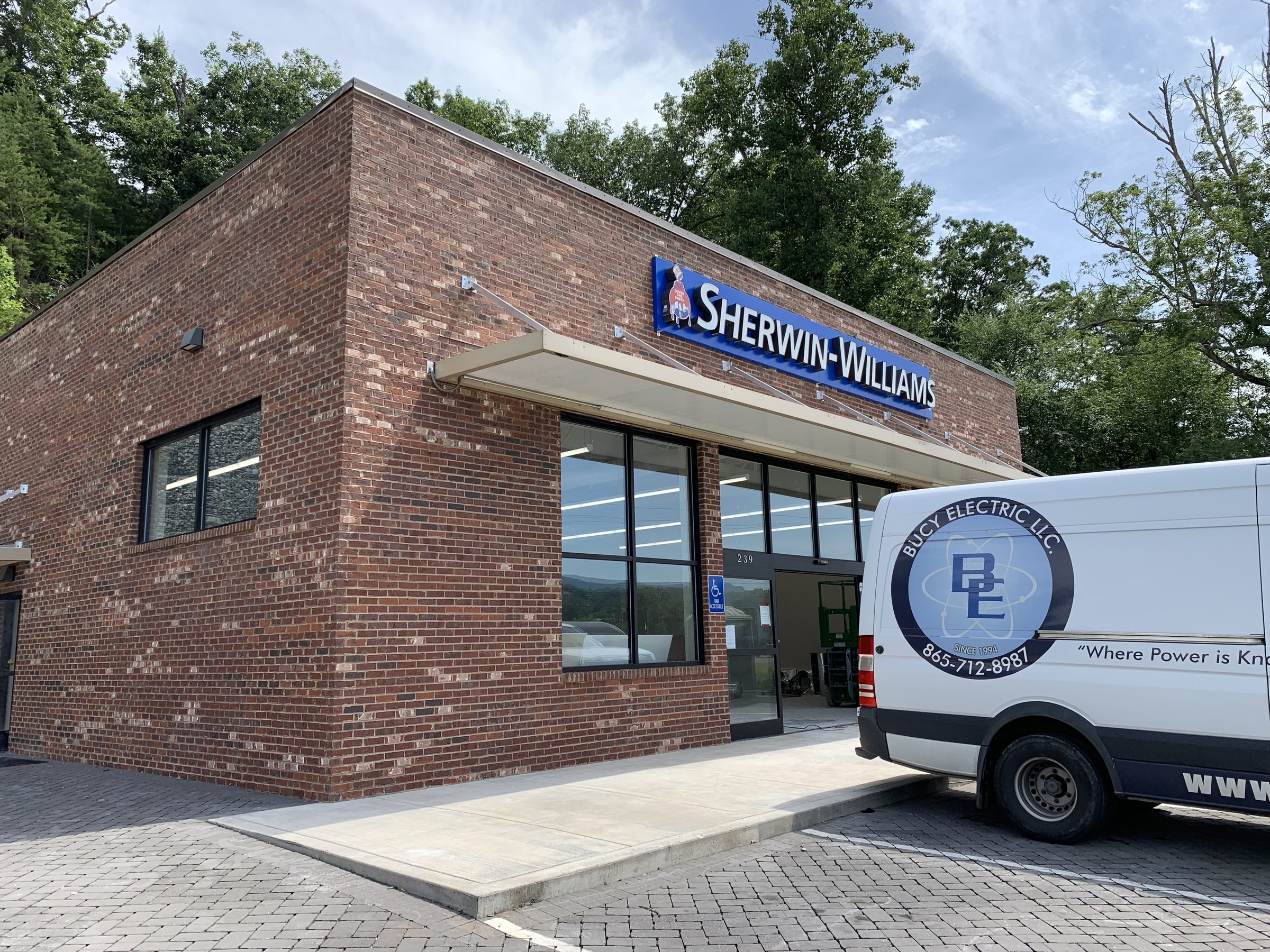 Bucy Electric service van parked at a commercial retail storefront